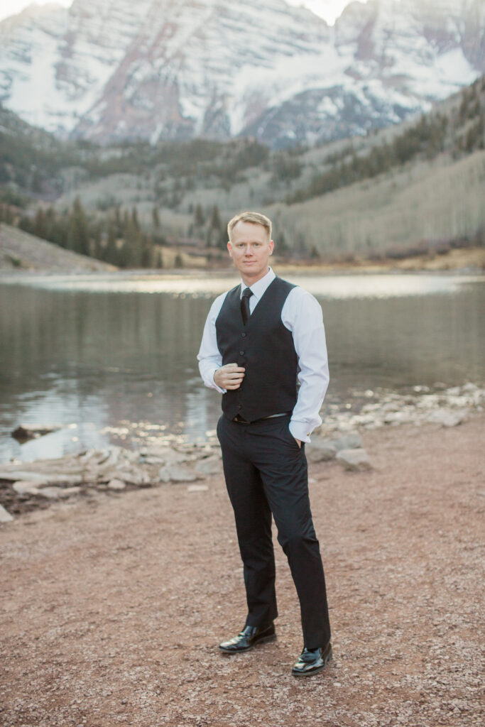 portrait of a man wearing black suit with vest looking toward the camera with mountains in the background 