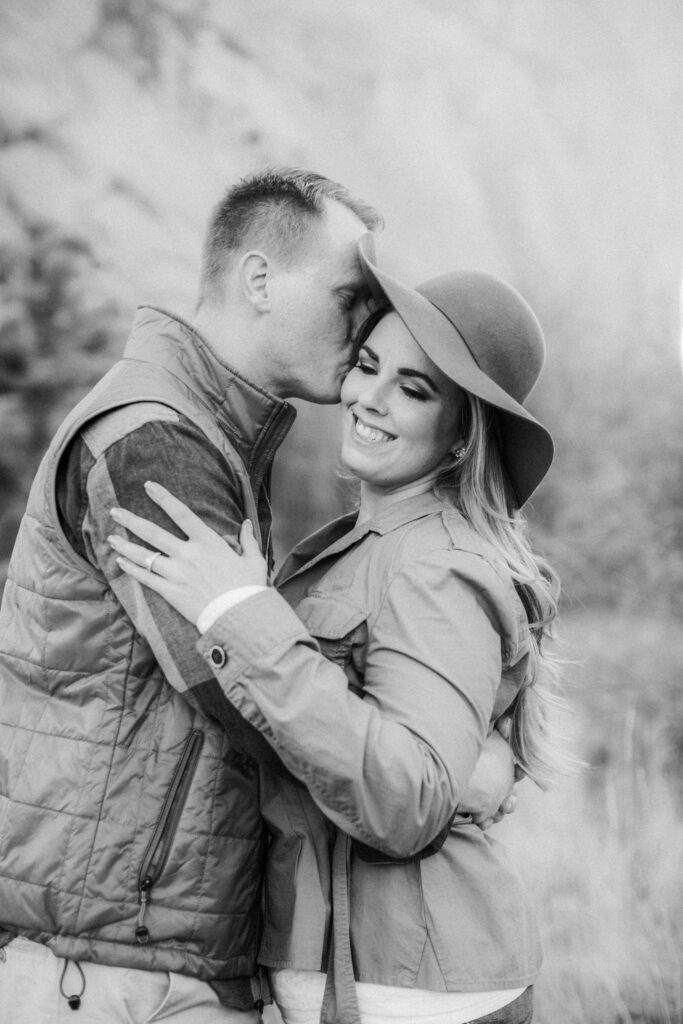 black and white image of man kissing woman's cheek 