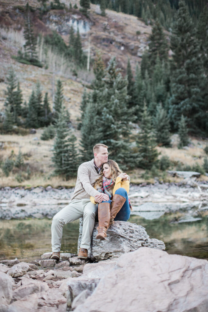 couple snuggling on a rock and enjoying nature 