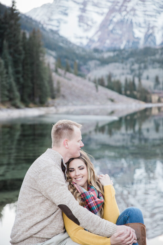 couple snuggling on a rock and enjoying nature 