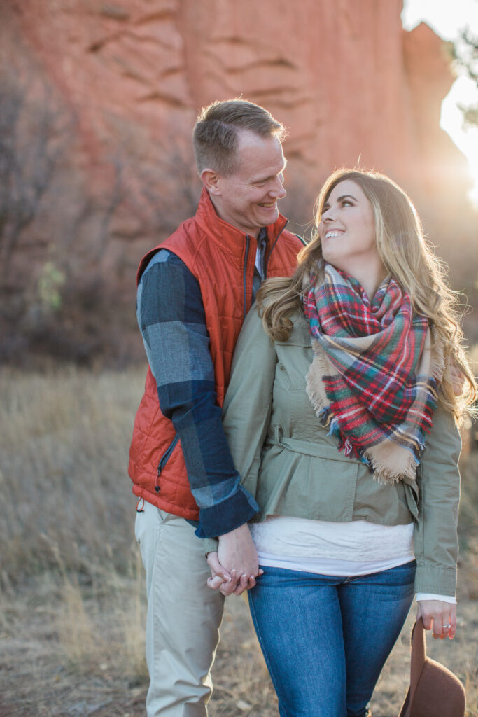 couple standing in embrace near red rocks 