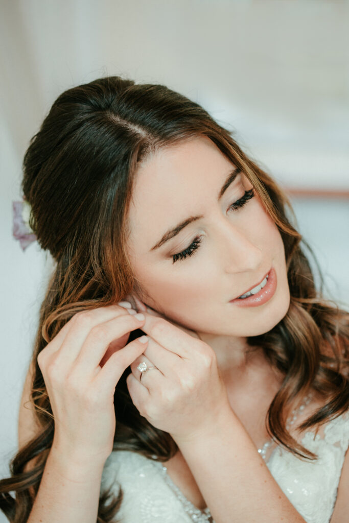 bride putting on earrings