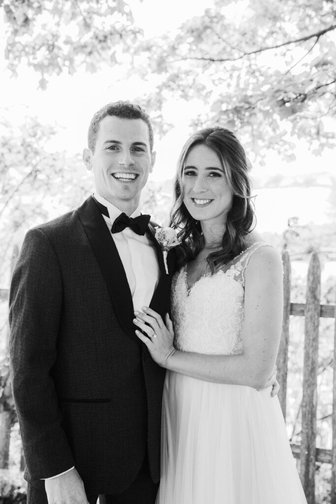 black and white of bride and groom smiling at the camera 