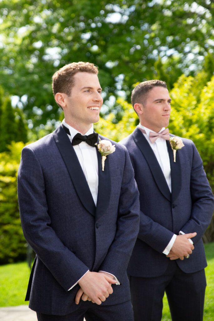 groom smiling as he sees his bride come down the aisle 