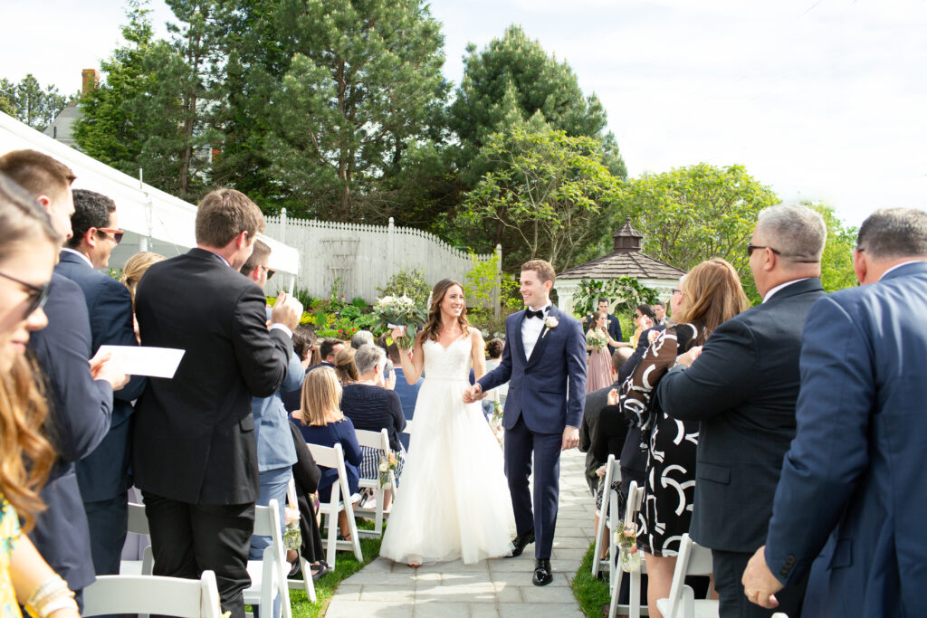 bride and groom celebrating as they walk down the aisle 