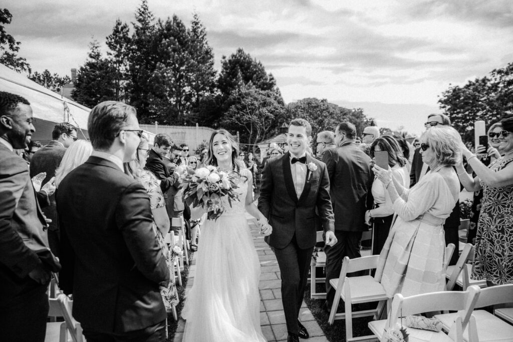 bride and groom celebrating as they walk down the aisle 