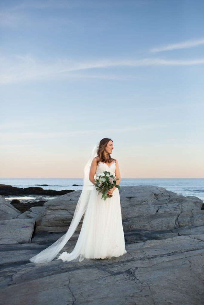 bride looking at the ocean on the rocks