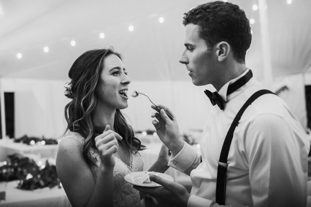 groom feeding the bride cake 