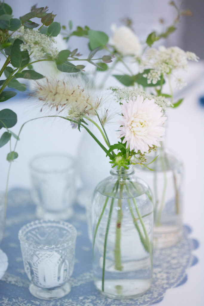 white flowers in vases on the tables