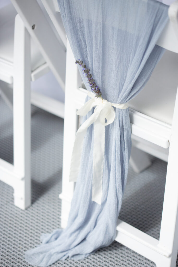 linen draped over brides chair with lavender tied to it