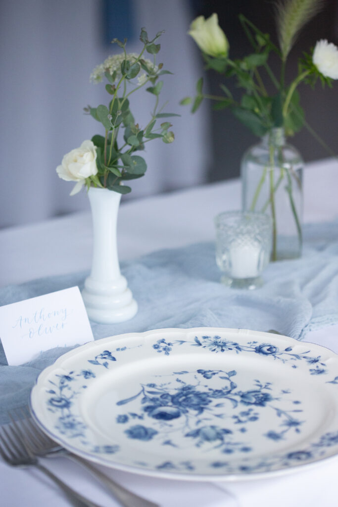 reception tables with blue and white patterned plates and linen table runner