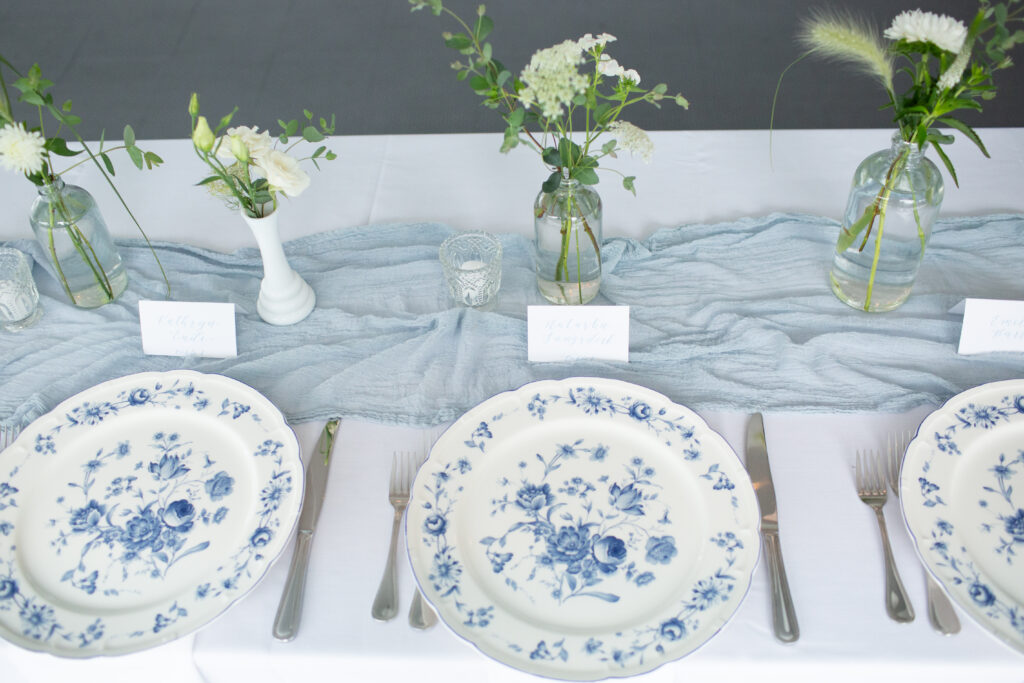 reception tables with blue and white patterned plates and linen table runner