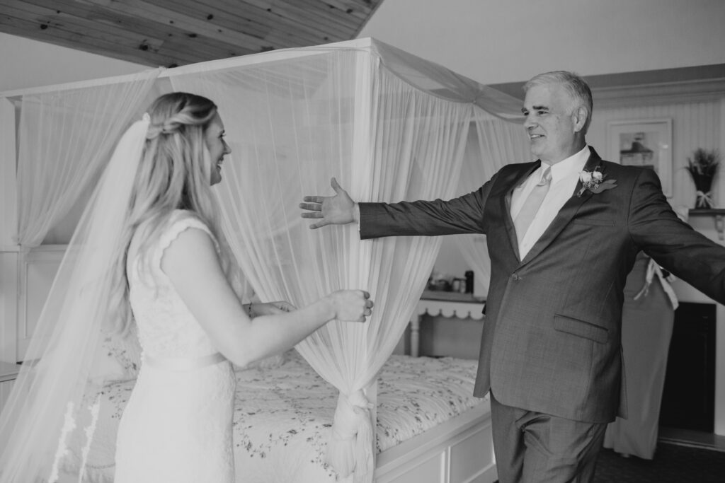 black and white photo of bride seeing her dad for the first time that day