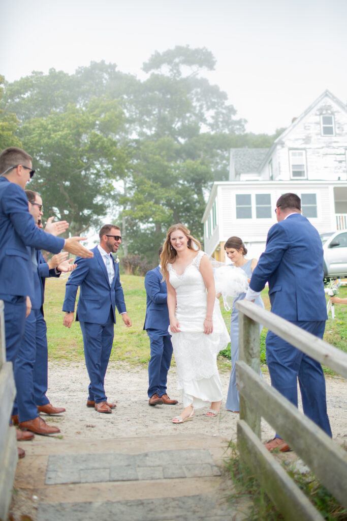 bride walking down walkway to get to groom on beach 