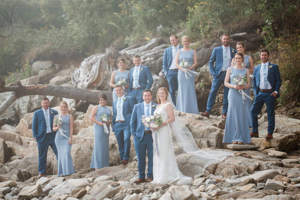 wedding party on the rocks wearing blue suits and periwinkle dresses 