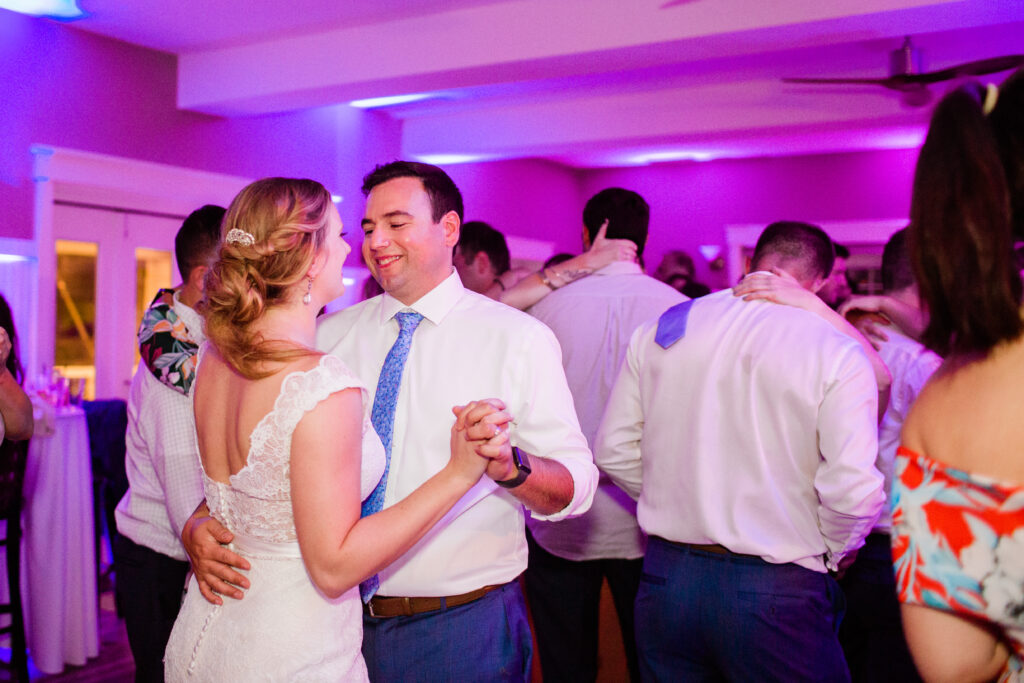 bride and groom dancing with friends and family on the dance floor