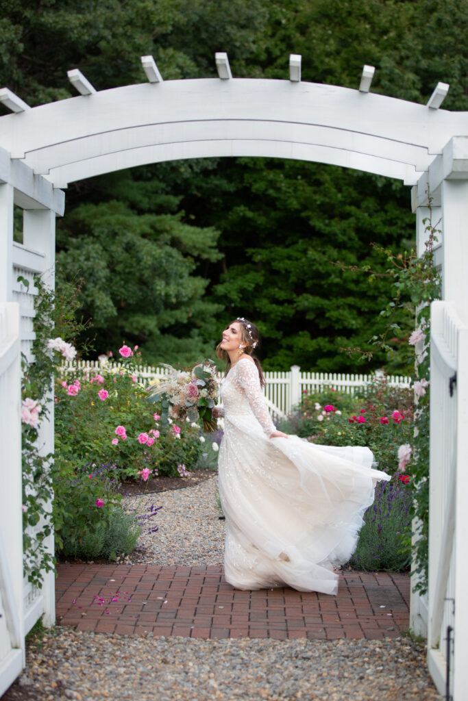 bride playing with dress in rose garden 