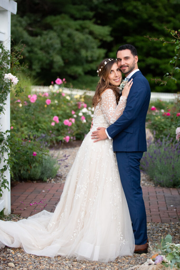 bride and groom walking in the rose garden 