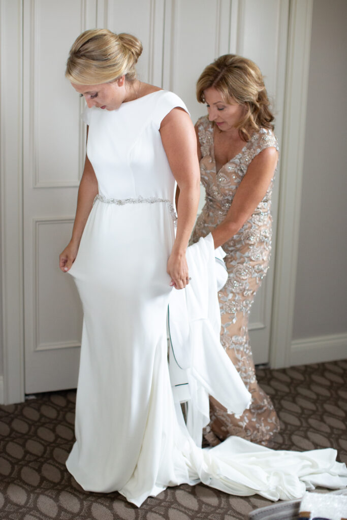 mother helping daughter with her dress 