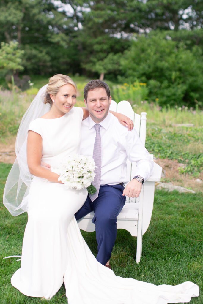 groom in navy and bride sitting in the gardens 