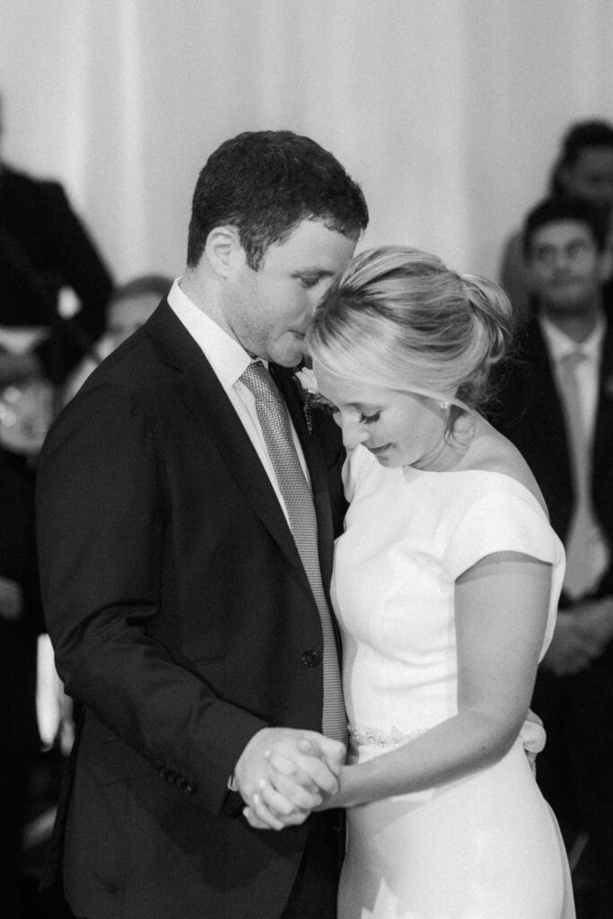 black and white picture of bride and groom dancing 