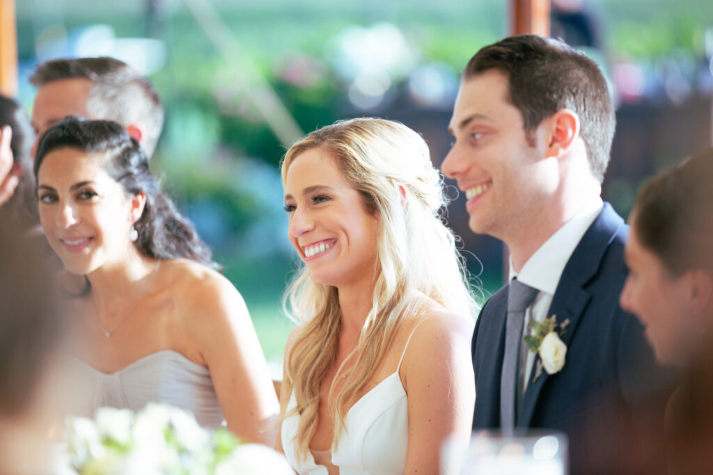 bride and groom smiling during the toasts