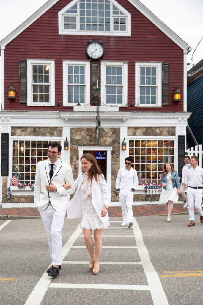 bride and groom wearing white walking in Kennebunkport to rehearsal dinner