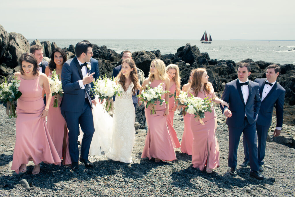 wedding party walking with sailboat in the background