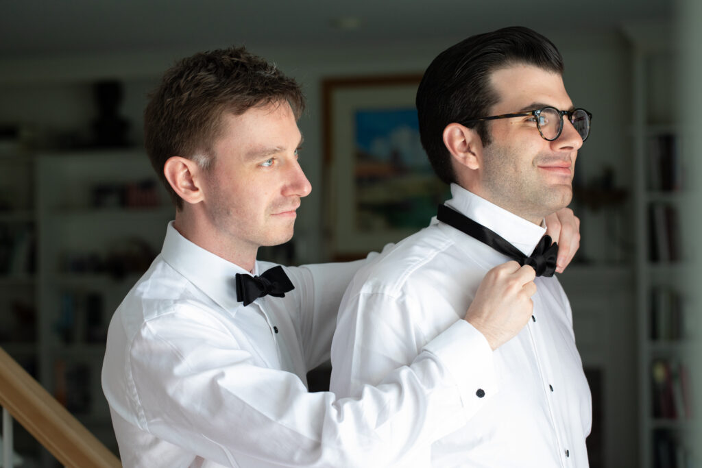 groom getting brother to help put on his bow tie 