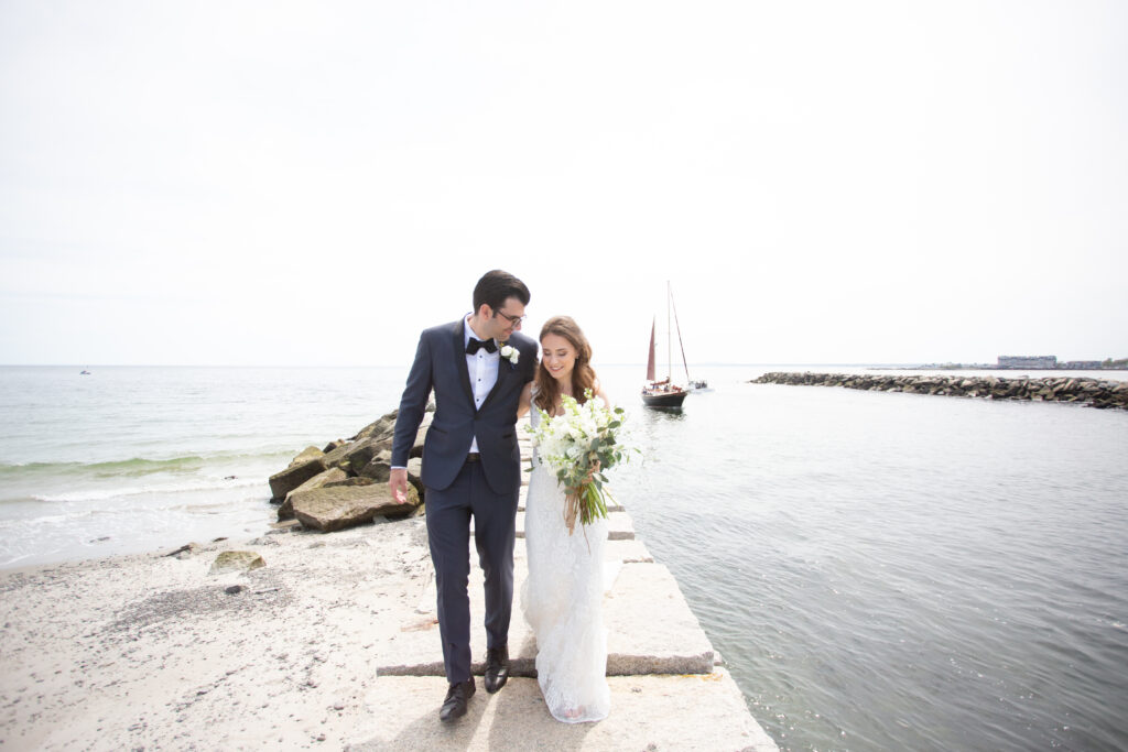 bride and groom walking on rocky jetty