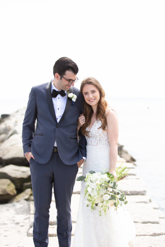 bride and groom standing on rocky jetty