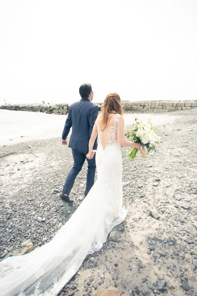 bride and groom walking from the back with brides dress trailing behind 