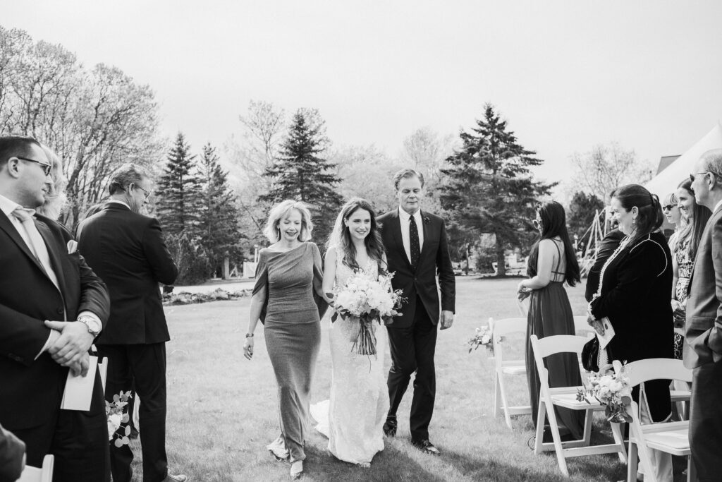 brides mother and father walking her down the aisle 