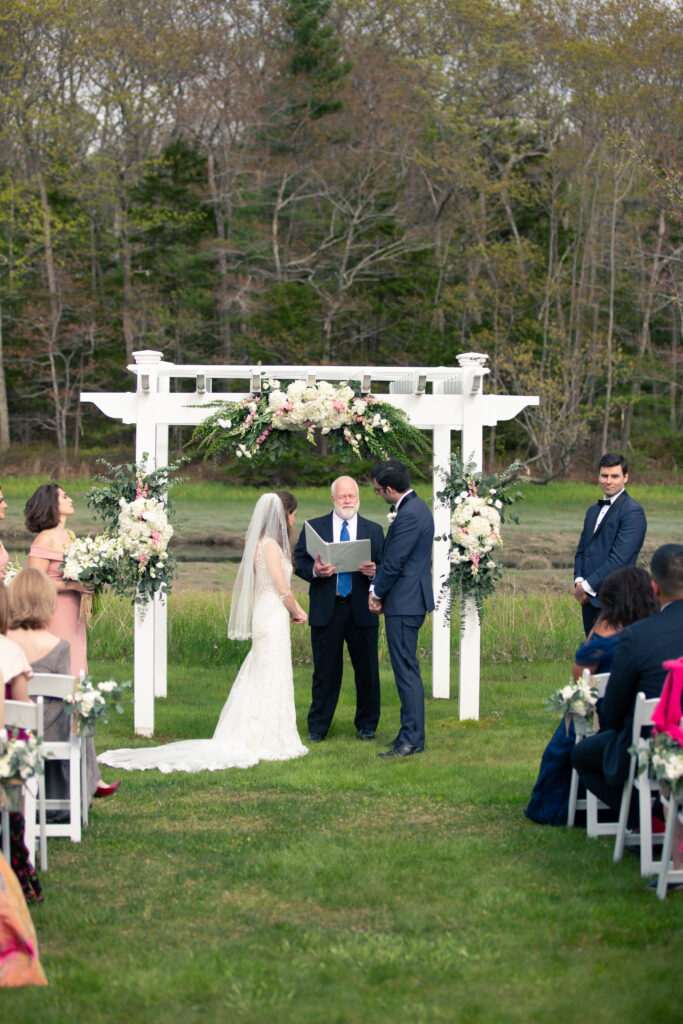 picture from the top of the aisle showing bride and groom at end of the aisle getting married by minister 