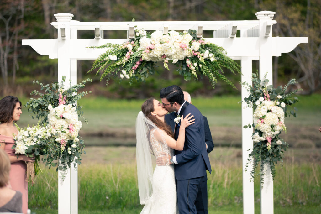 bride and groom sharing first kiss during wedding ceremony 