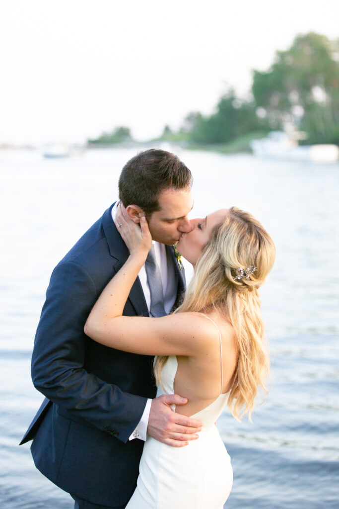 bride and groom kissing with the ocean in the background 