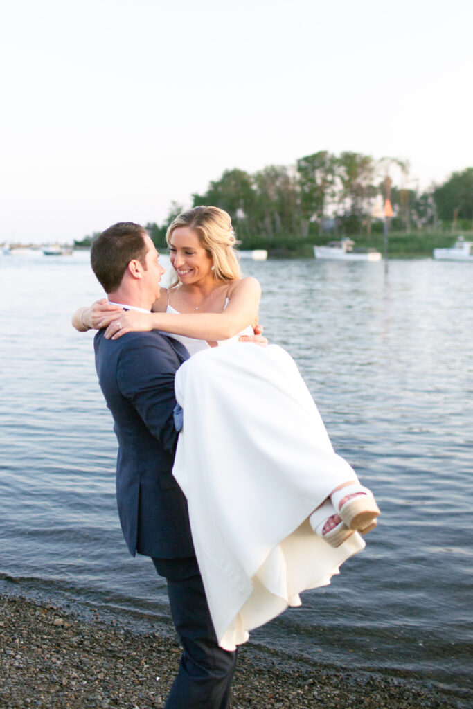 bride laughing while the groom spins her around in his arms 