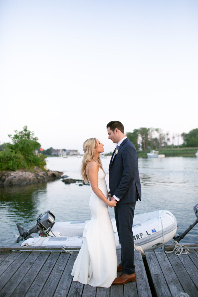 bride and groom looking at each other on the dock