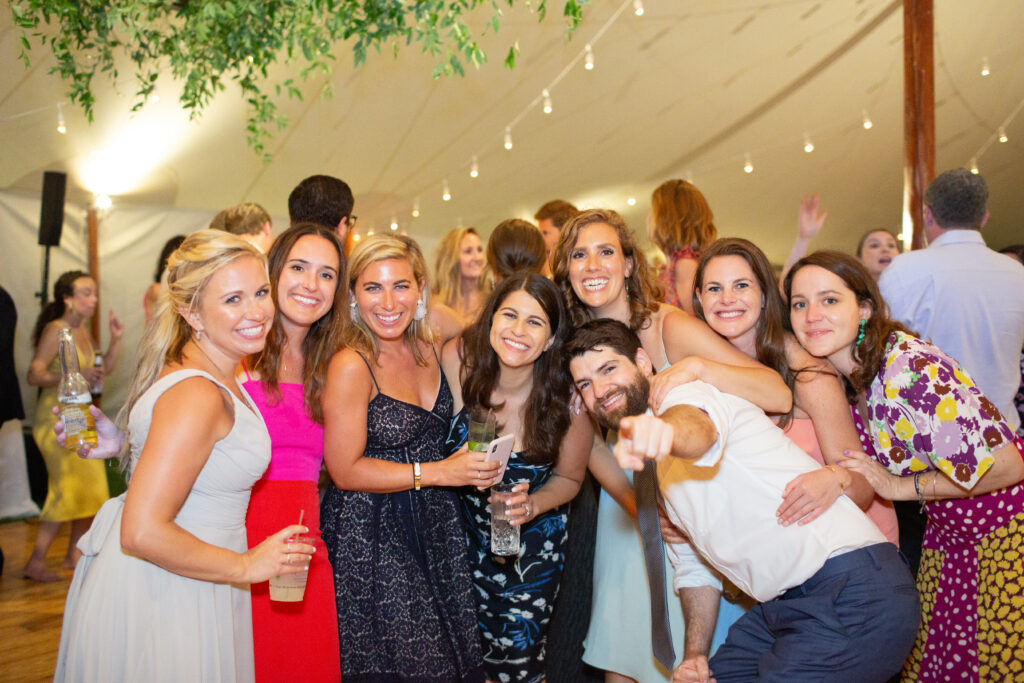 wedding guests together on the dance floor looking at the camera 