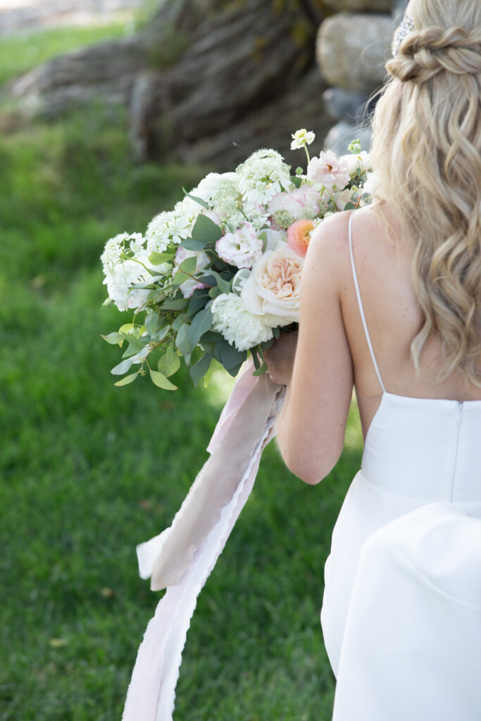 bride walking with bouquet from behind