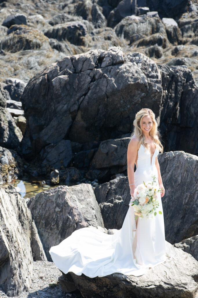 bride standing on the rocks at the beach