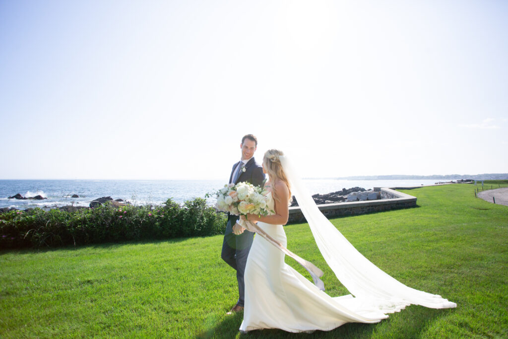 bride and groom walking holding hands by the ocean 