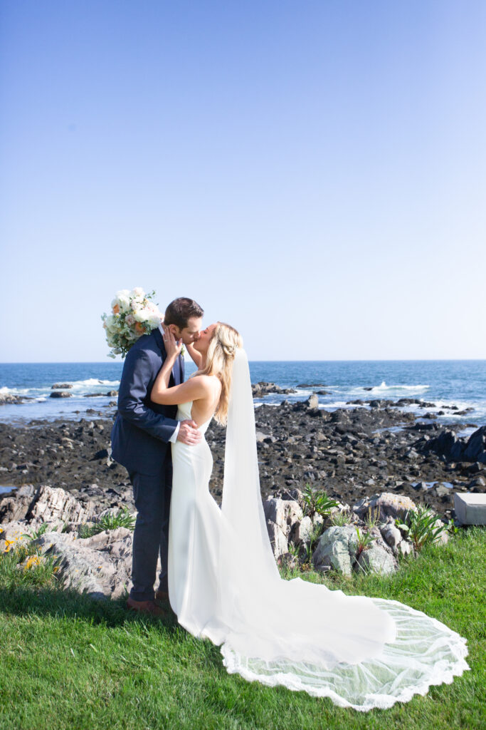 bride and groom kissing by the ocean 