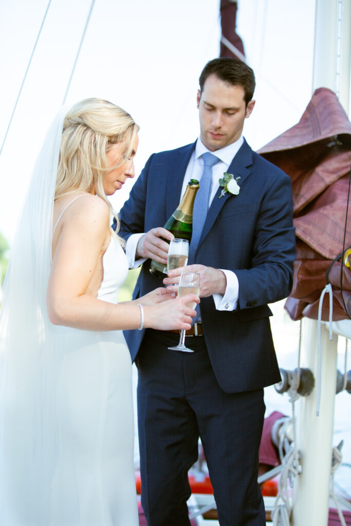 bride and groom on sailboat having champagne toast 