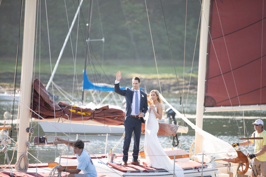 bride and groom arriving at ceremony on sailboat veil blowing in the wind