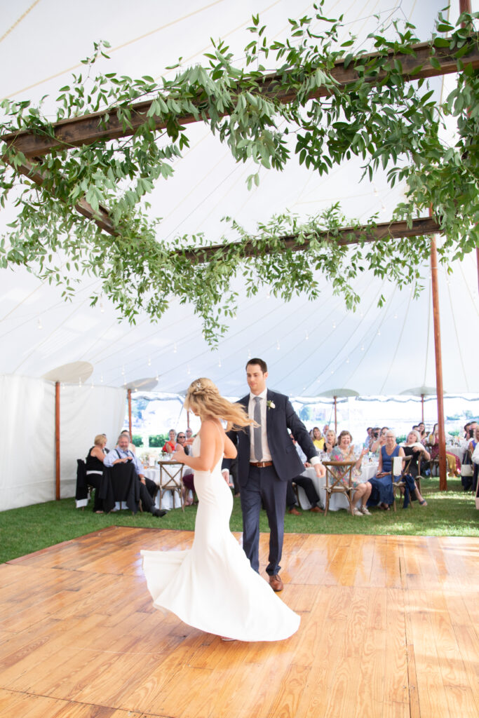 bride and groom dancing their first dance under the floral ceiling installation 