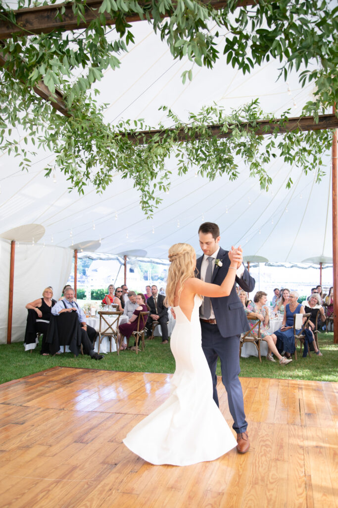 bride and groom dancing their first dance under the floral ceiling installation 