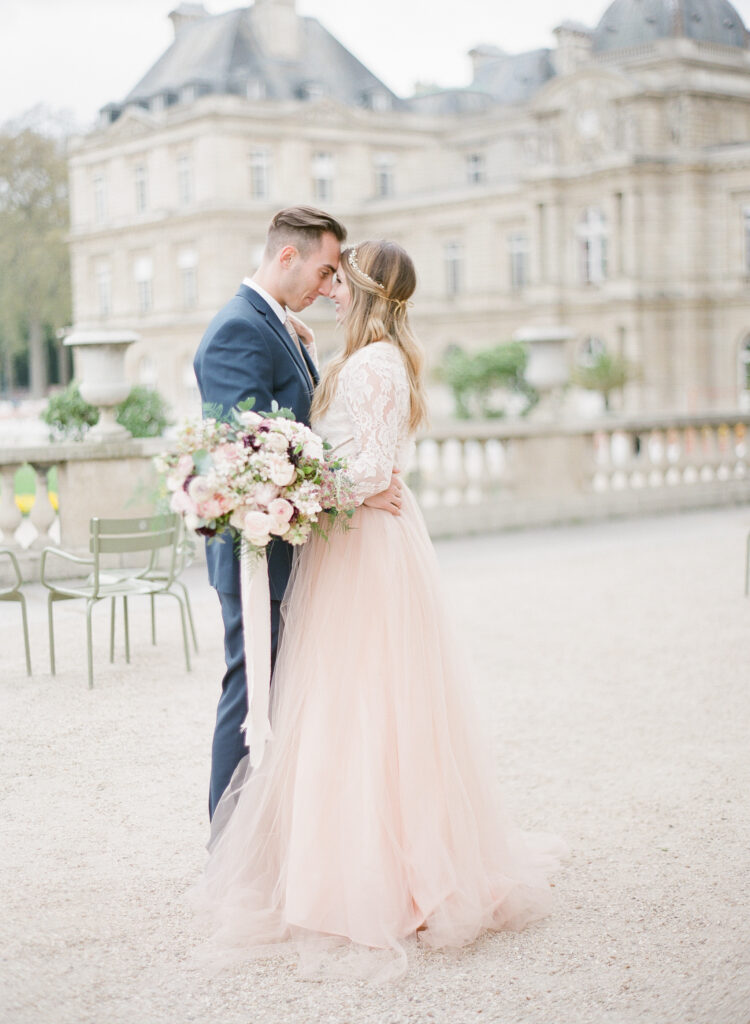 bride and groom facing each other in front of jardin de luxembourg 