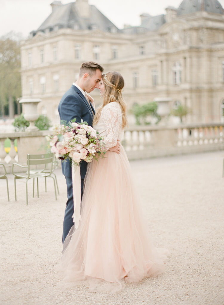 bride and groom in front of palace at jardin de luxembourg 