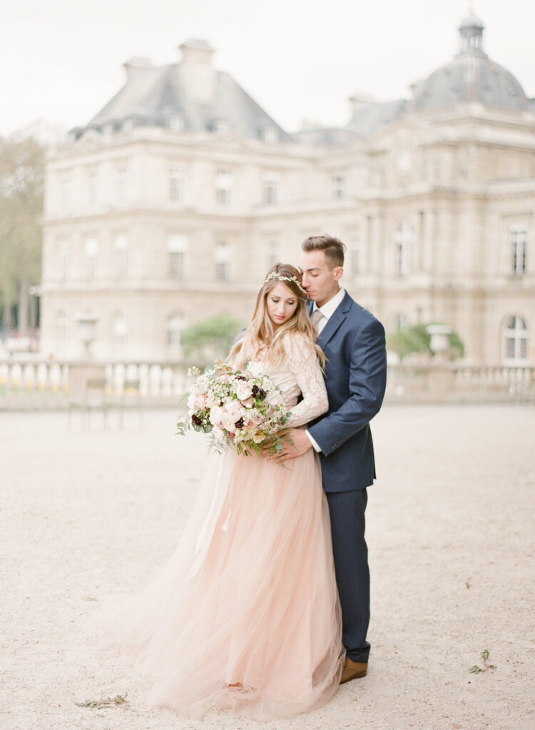 bride and groom in front of palace at jardin de luxembourg 